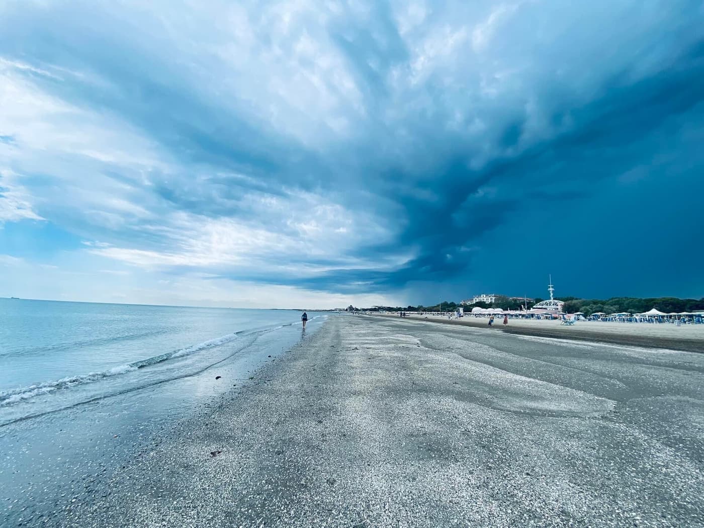 Ein weiter, leerer Strand am Lido unter dramatischem Himmel
